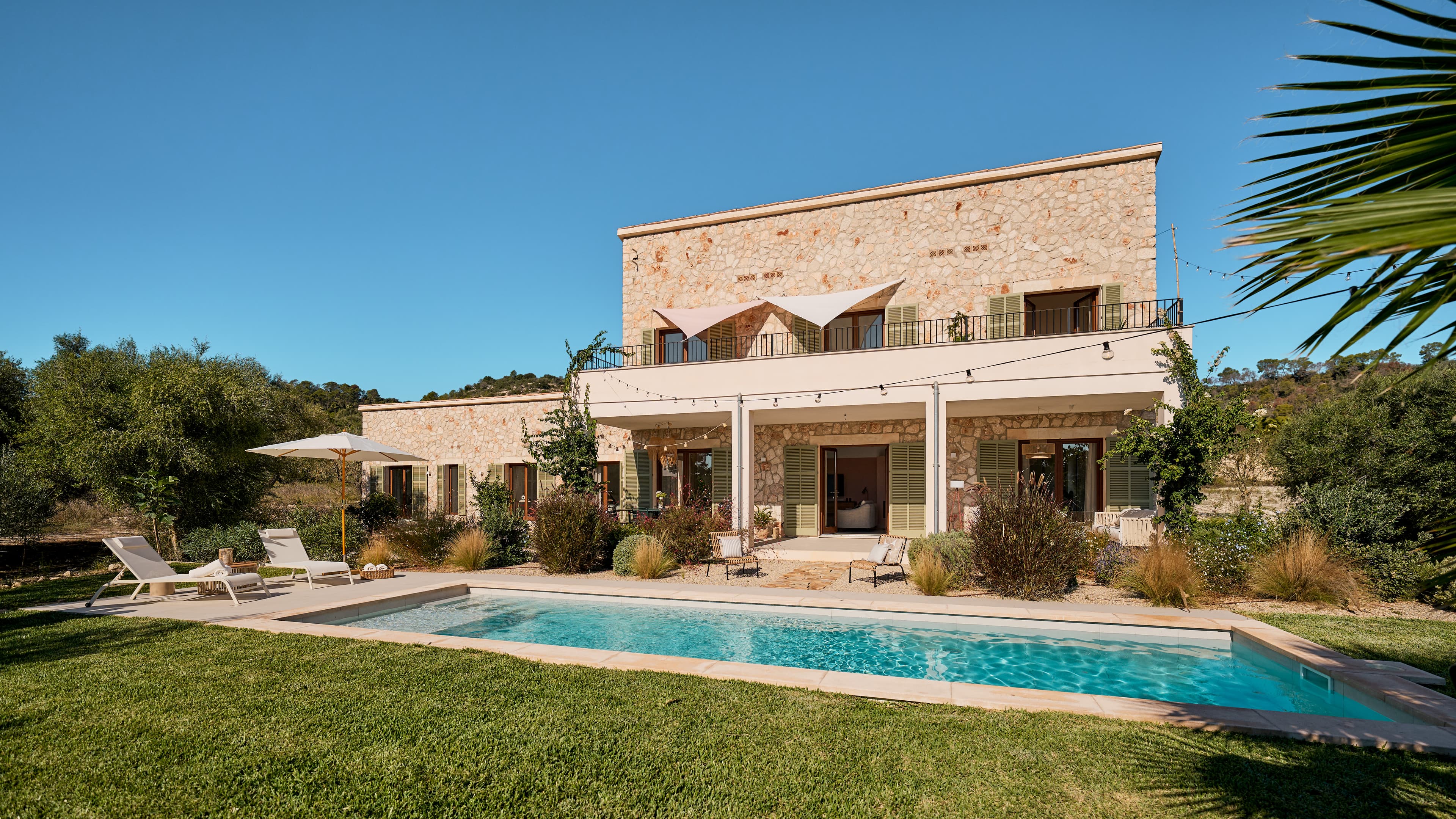 Traumhaus auf Mallorca mit Natursteinfassade, mediterranen Garten, großem Pool und Sonnenterrasse.